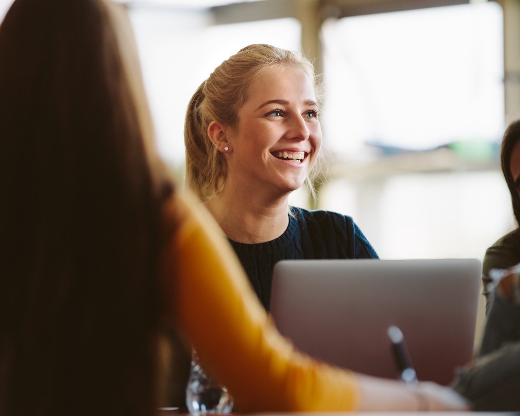 jongvolwassen vrouw met laptop die blij is